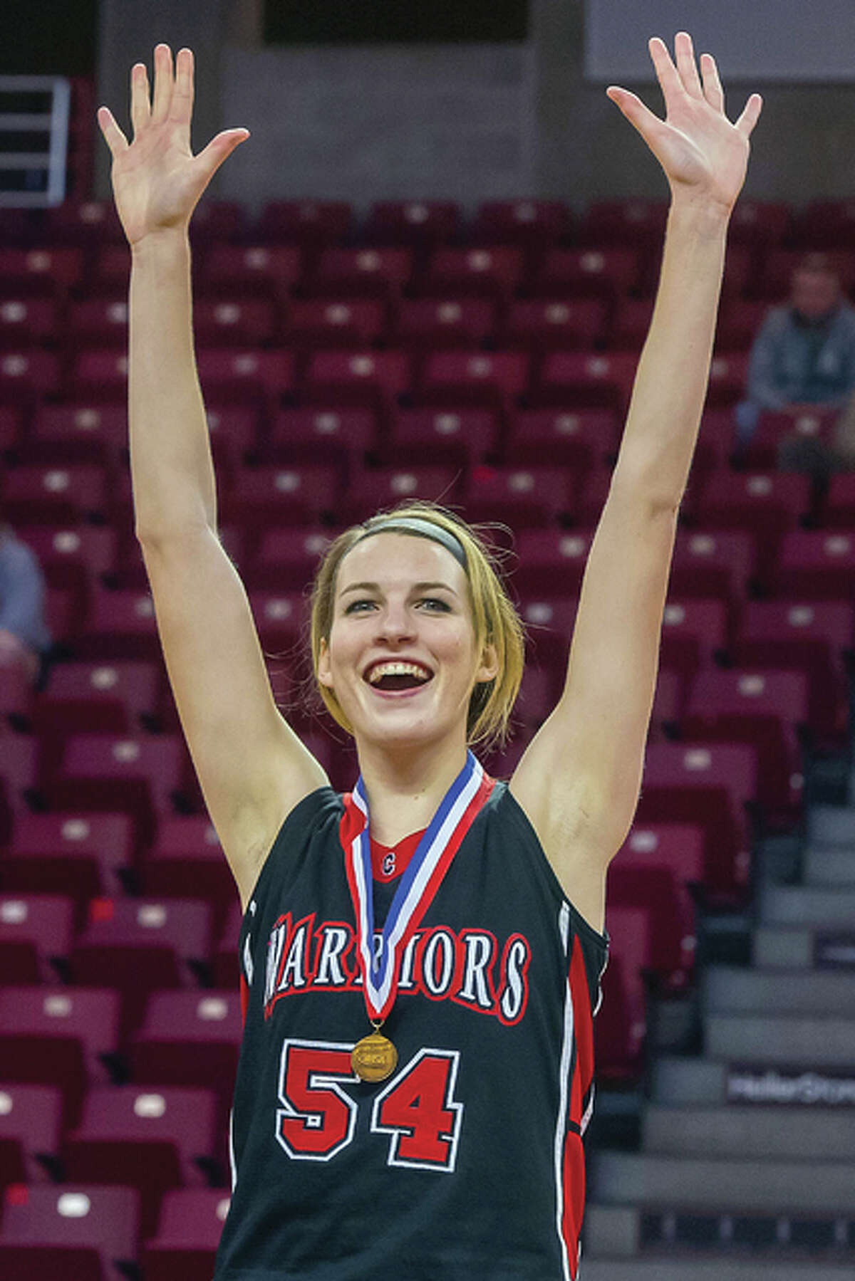 Calhoun’s Grace Baalman celebrates after receiving her state championship medal Saturday in Normal. She scored 17 points and helped the Warriors to a 60-56 win over Mowequa Central A&M in the Class 1A state championship game at Redbird Arena.