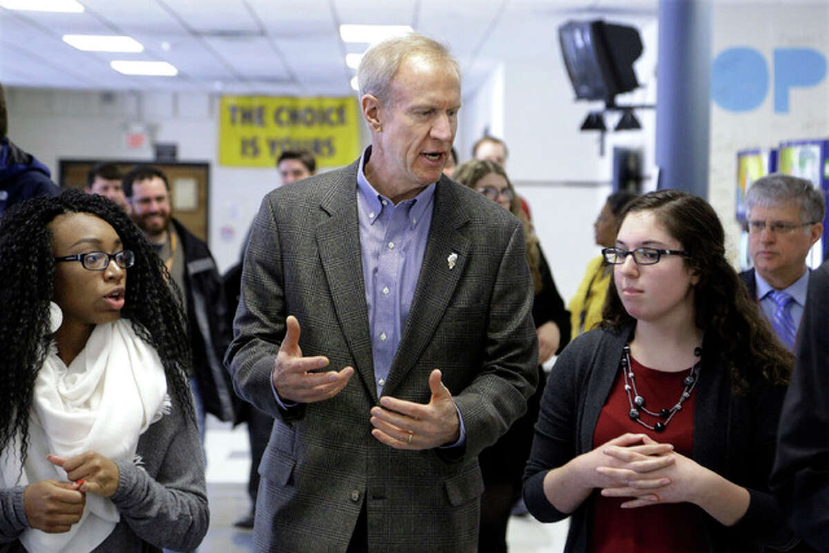 In this Feb. 24 photo, Illinois Gov. Bruce Rauner visits with students hoping to attend college during a visit to Southeast High School in Springfield, Ill., where he discussed his education agenda. Rauner is calling once again for deep cuts in state funding for higher education, showing how tempting a target universities continue to be for a state desperate to get its budget under control.