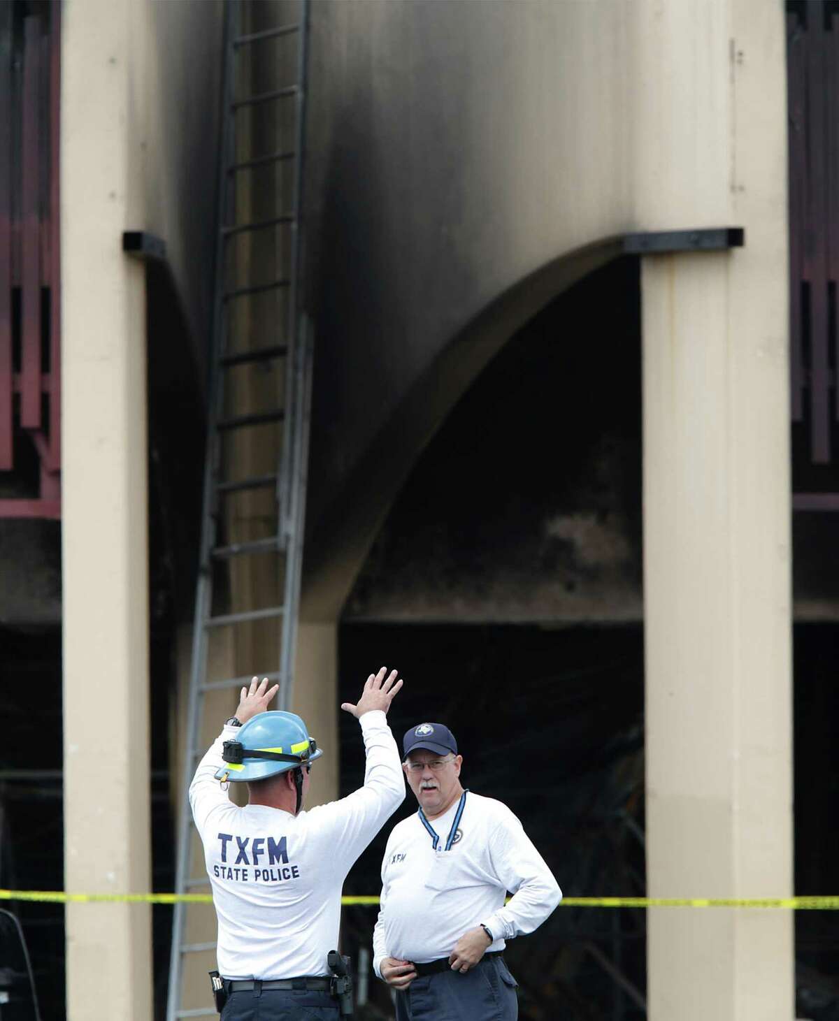 Members of the Texas Fire Marshall's office discuss the inspection of the fire where San Antonio firefighter Scott Deem was killed during a blaze at the Northwest Side strip mall on Ingram Rd.