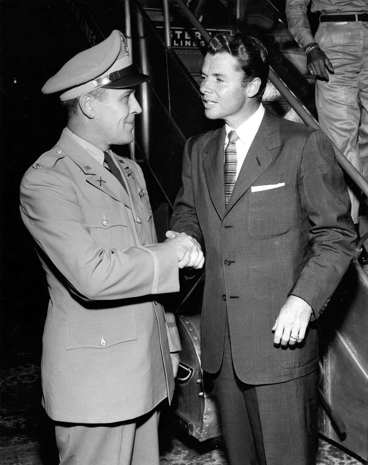 08/1955 - (R-L) Audie Murphy, Congressional Medal of Honor winner and star of the movie version of his adventures "To Hell and Back," was welcomed to Houston by Maj. Paul E. Butts, commanding officer of the Houston Recruiting Main Station when Murphy arrived at International Airport at midnight Wednesday by Eastern Air Lines from San Antonio. Murphy is in Houston for personal appearances at the Majestice Theater in connection with the premiere of his movie.