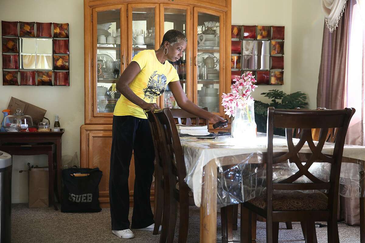 Home health care provider Sonia Wright organizes the table at the home of Johnny and Margie Cherry on Friday, February 9, 2018, in San Francisco, Ca.