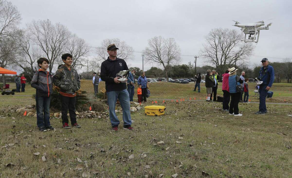 San Antonio Drones' Chris Fisher (third from left) shows siblings Zeus and Phoenix (left) Blowe how to fly a drone as hobbyists and the public attend the 2018 San Antonio Winterfest Drone Fly-in at the former Alamo Golf Course on Saturday, Feb. 10, 2018. The event featured flying demonstrations, workshops and exhibits on the Northwest Side. The event was held in what is called Class G airspace, which has no restrictions on drone flight other than basic rules. (Kin Man Hui/San Antonio Express-News)