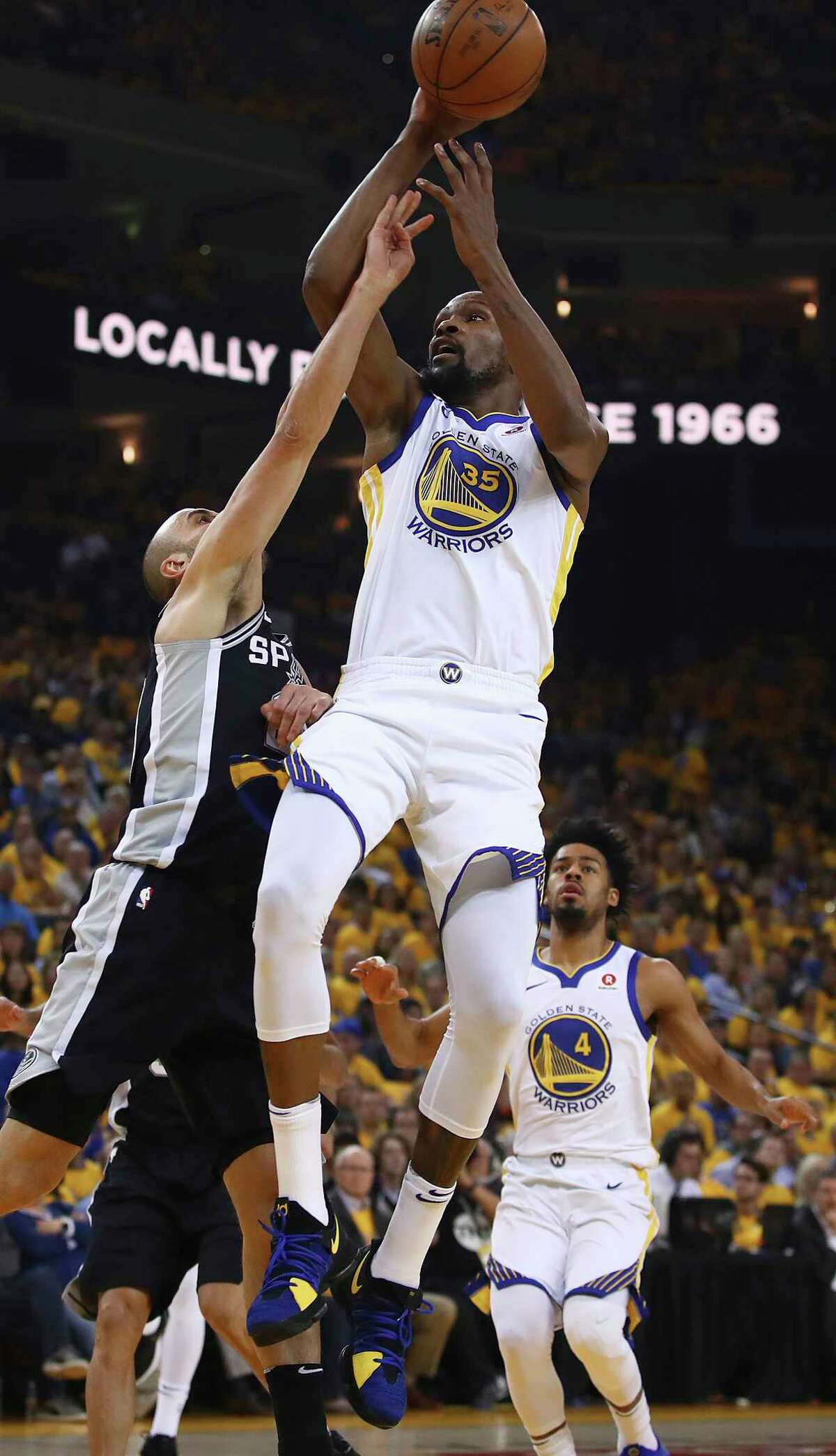 Golden State Warriors' Kevin Durant (35) shoots against San Antonio Spurs' Manu Ginobili, left, during the first quarter in Game 5 of a first-round NBA basketball playoff series Tuesday, April 24, 2018, in Oakland, Calif. (AP Photo/Ben Margot)
