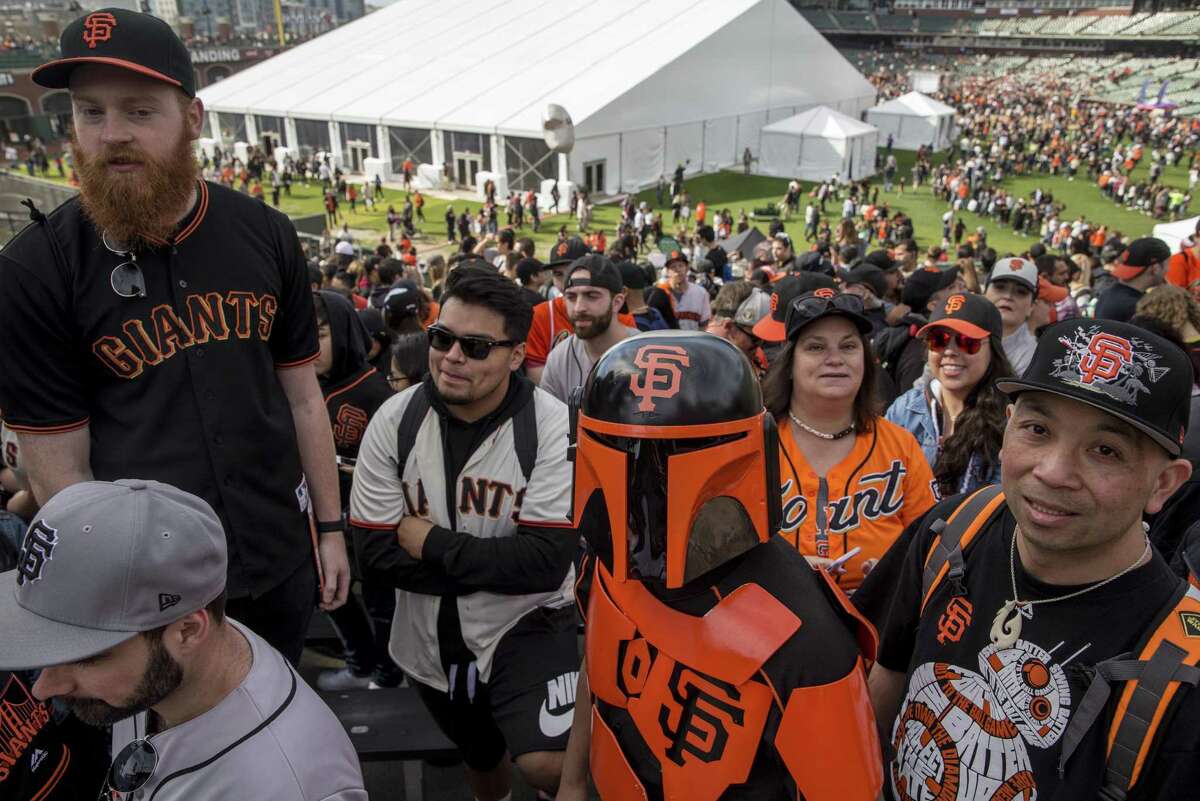 Robert Samson, center, of Benicia, dresses as a San Francisco Giants-themed Star Wars character Boba Fett during San Francisco Giants FanFest.