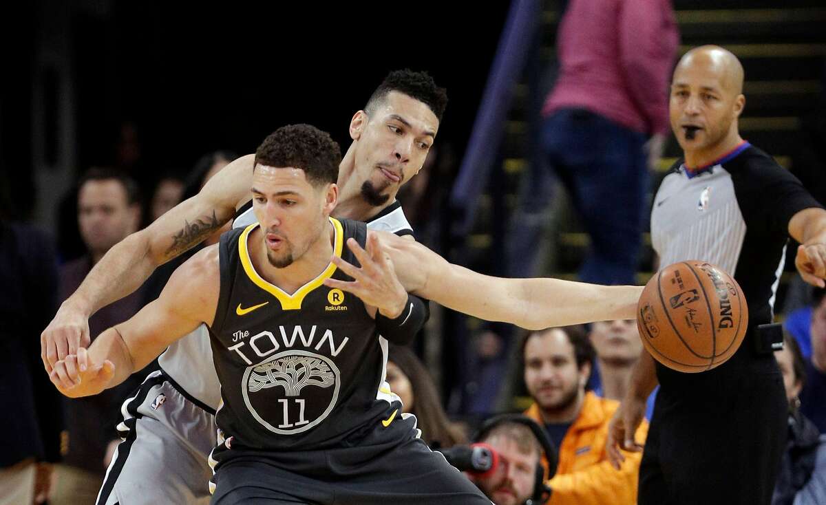 Danny Green (14) goes for the ball while defending against Klay Thompson (11) in the first half as the Golden State Warriors played the San Antonio Spurs at Oracle Arena in Oakland, Calif., on Saturday, February 10, 2018.