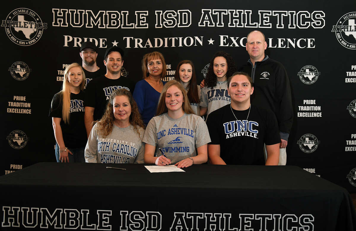 Alexis Baker, front center, of Kingwood Park High School, with her mom Loretta, front left, is all smiles after signing her letter of intent to swim for the University of North Carolina at Asheville during the Humble ISD Athletics Signing Day at The Overlook in Atascocita on Feb. 7, 2018. (Photo by Jerry Baker/Freelance)
