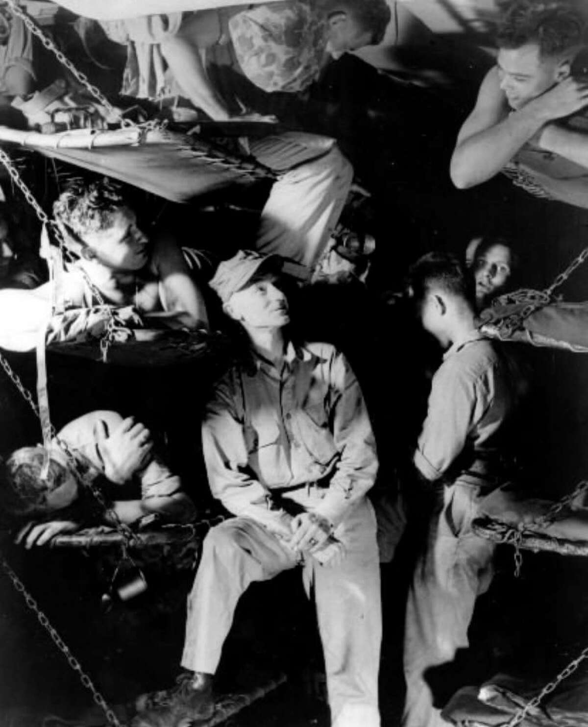 American war correspondent Ernie Pyle, center, talks with Marines below decks on a U.S. Navy transport while en route to the invasion of Okinawa during World War II, in this March 1945 file photo. Pyle was killed on April 18, 1945, by Japanese machine-gun fire on the island of Ie Shima in the southwestern Pacific Ocean near Okinawa. (Associated Press archive)