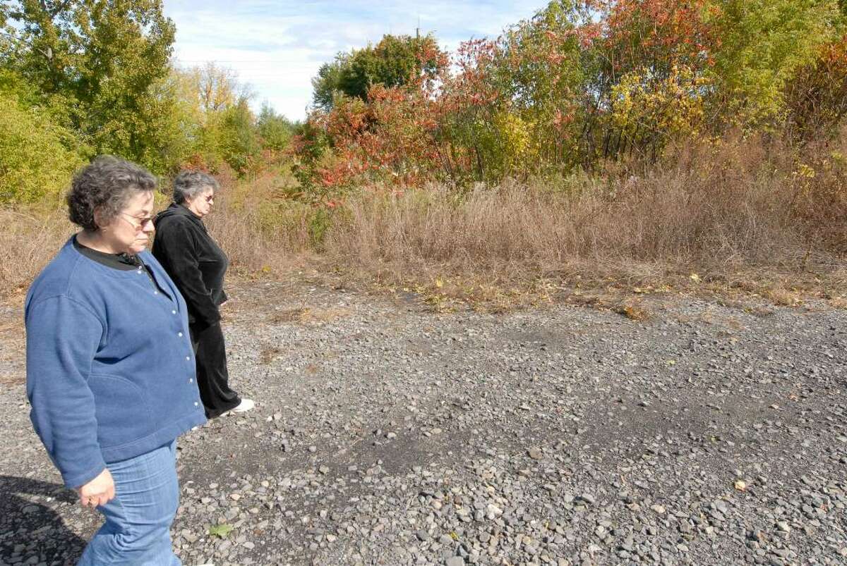 Front Street residents Mary Ann Ruscitto, far left, and her sister Carmella Ruscitto walk along the edge of the property proposed for Stockade Harbour waterfront residential community in Schenectady. (Michael P. Farrell / Times Union )