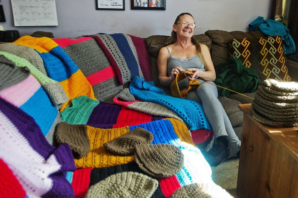 Debra Parady of Sanford poses for a portrait with items she has crocheted for veterans inside her home on Monday, Feb. 12, 2018. (Katy Kildee/kkildee@mdn.net)