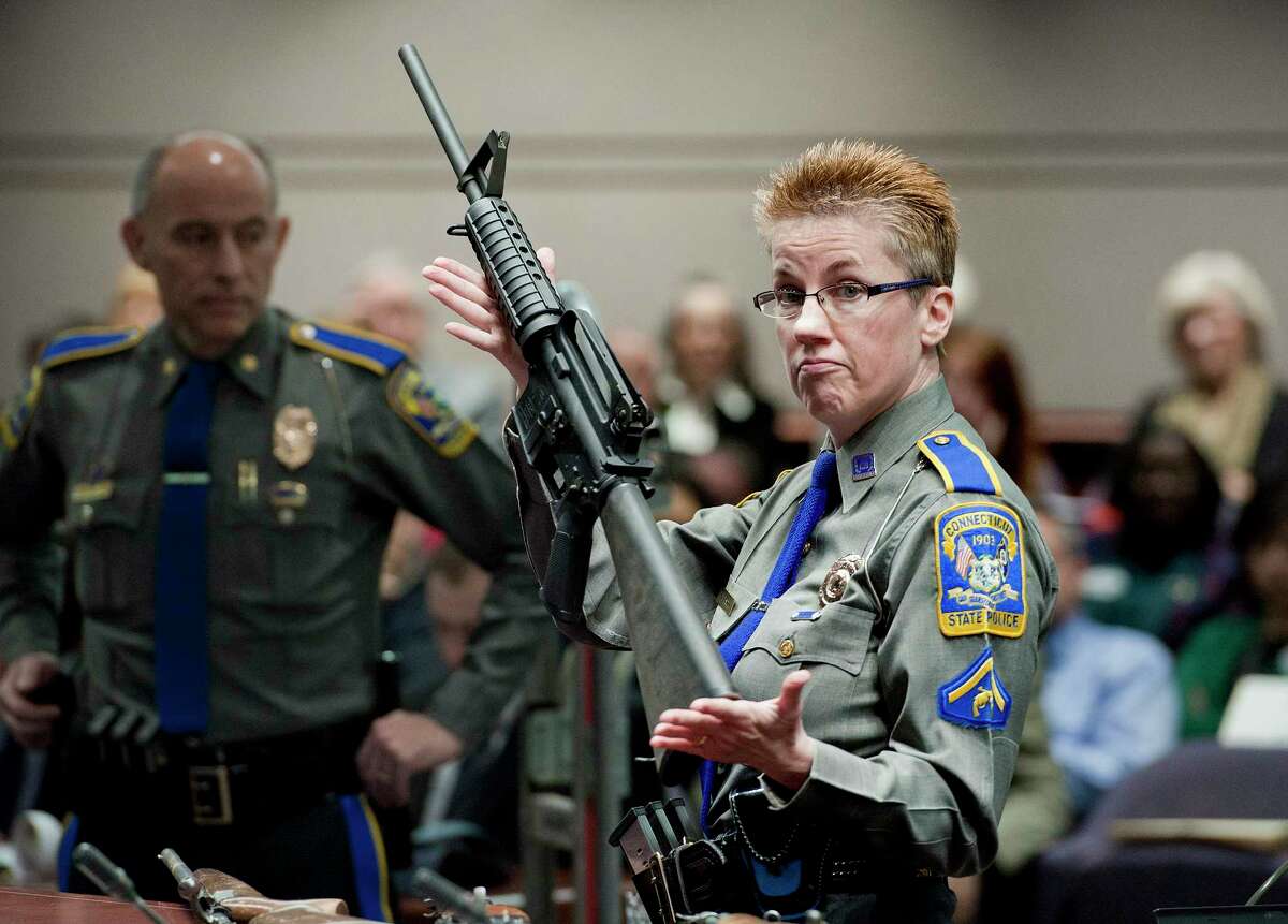 Barbara Mattson of the Connecticut State Police displays a Bushmaster AR-15 rifle in 2013 at a legislative hearing. That is the same make and model of gun used in the Sandy Hook School shooting. Gun maker Remington was cleared of wrongdoing in the case.