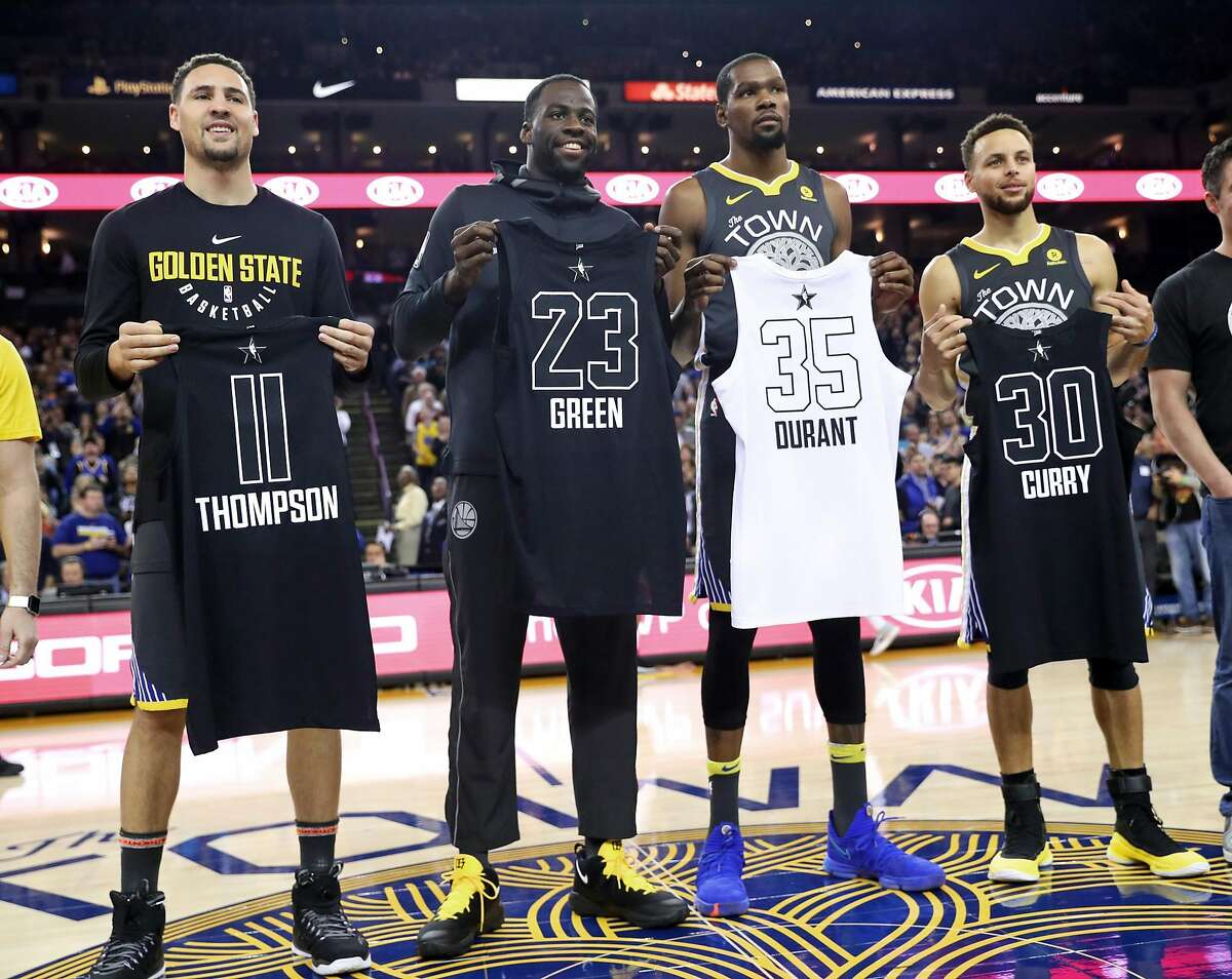 Golden State Warriors' Klay Thompson, Draymond Green, Kevin Durant and Stephen Curry pose with their All Star Game jerseys at Oracle Arena in Oakland on February 12, 2018.