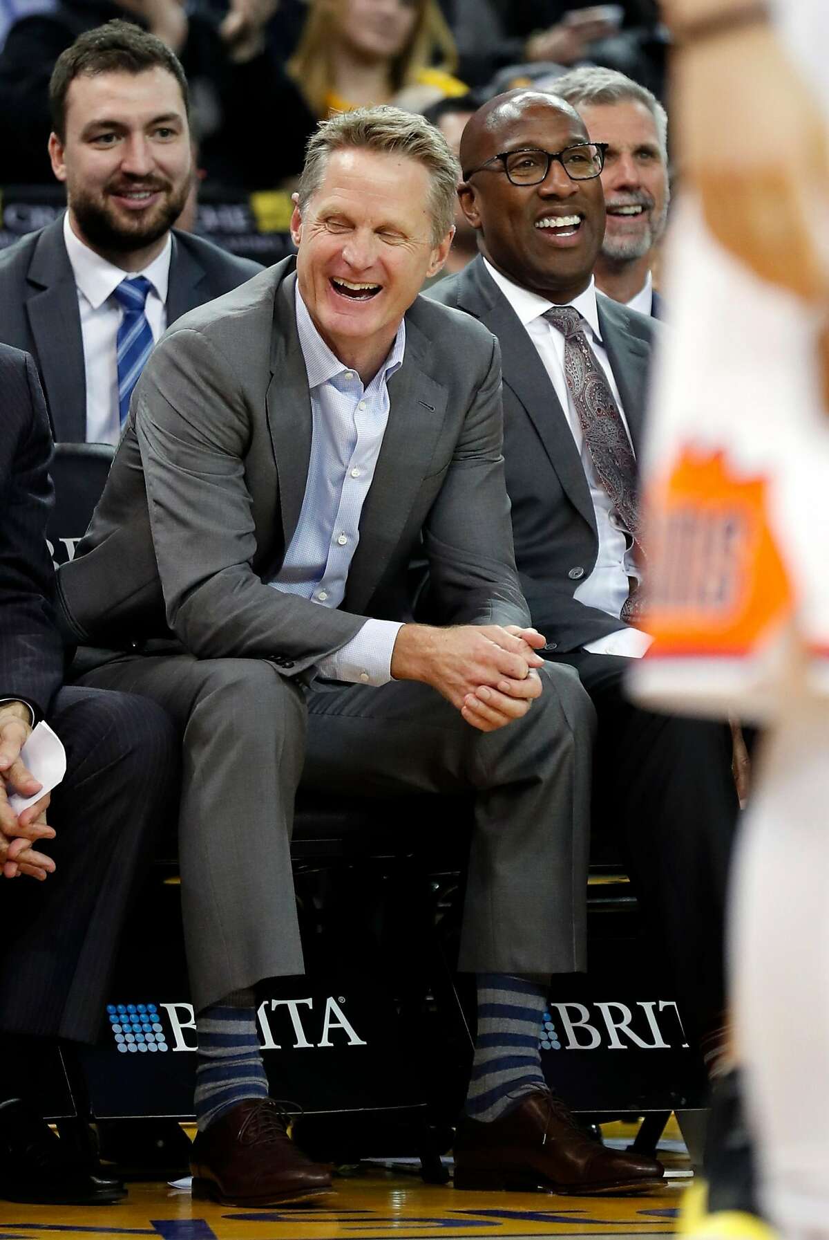(left to right) Golden State Warriors' coaches' Chris DeMarco, Steve Kerr, Mike Brown and Bruce Fraser enjoy the 3rd quarter of Warriors' 129-83 win over Phoenix Suns during NBA game at Oracle Arena in Oakland, Calif., on Monday, February 12, 2018.