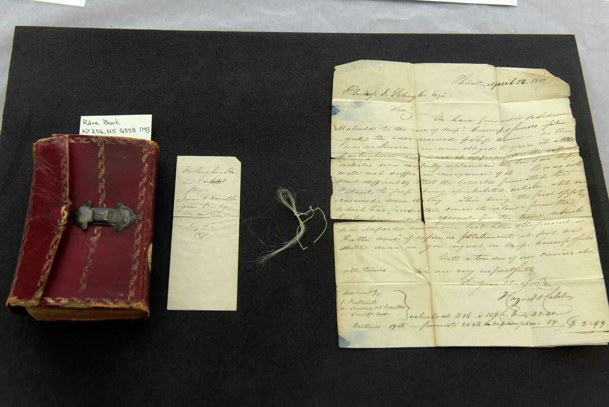 From left to right, a view of a book, Gaine's Universal Register, that is believed to have belonged to Philip J. Schuyler, an envelope that was inside the book and some strands of hair of George Washington's hair and a letter written to Philip J. Schuyler, seen here at Union College on Thursday, Feb. 8, 2018, in Schenectady, N.Y. Philip J. Schuyler was the son of General Philip Schuyler. (Paul Buckowski/Times Union)