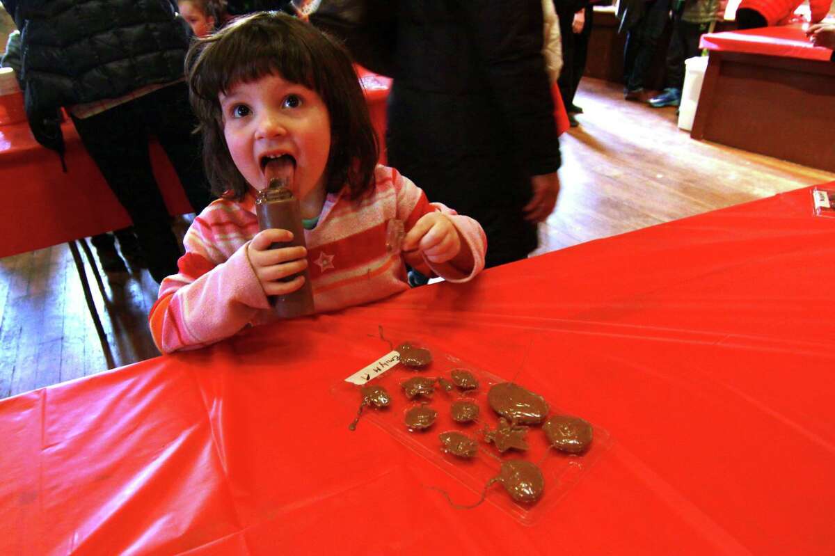 Emily Murphy, 4, of Monroe, licks the bottle of chocolate she used to make her own Valentine Day candies during the Kids' Candymaking Workshop held at the Pequot Library in Southport, Conn., on Tuesday Feb. 13, 2018. The kids from kindergarten to 8th grade were able to make chocolate treats for Valentine's Day. They were also able to use crafts to create their own gift box and card. For future events or information, visit: www.pequotlibrary.org