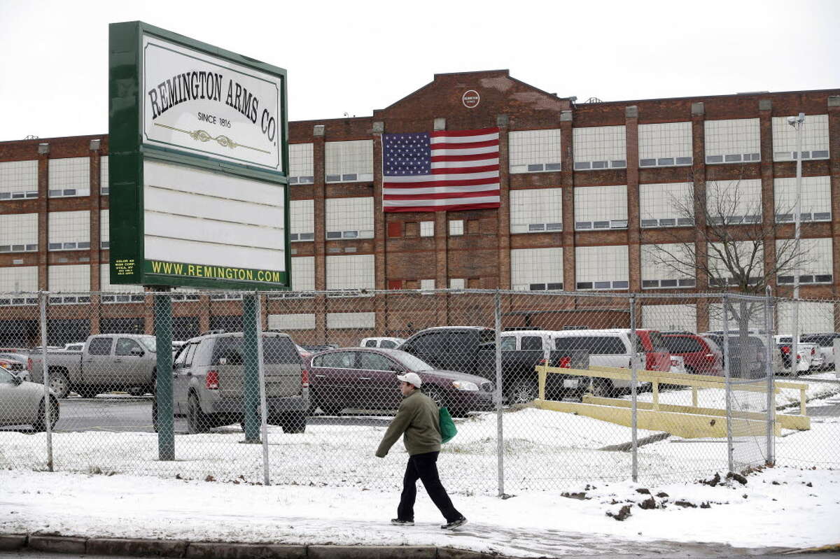 In this Thursday, Jan. 17, 2013, photo, a man walks past the Remington Arms Company in Ilion, N.Y. (AP Photo/Mike Groll)