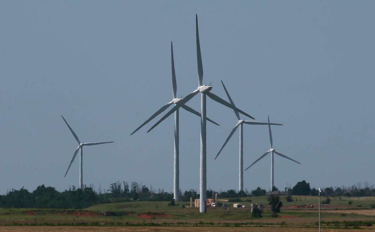 FILE - In this Monday, June 12, 2017 file photo, wind turbines are pictured near El Reno, Okla. Oklahoma rolled out the red carpet to the growing wind industry two decades ago with the promise of generous state tax incentives and a steady stream of wind sweeping down the Central Plains. But with budget shortfalls that have persisted for several years, lawmakers have already scaled back almost all of the incentives and are now looking to impose a new production tax on the industry. (AP Photo/Sue Ogrocki, File)