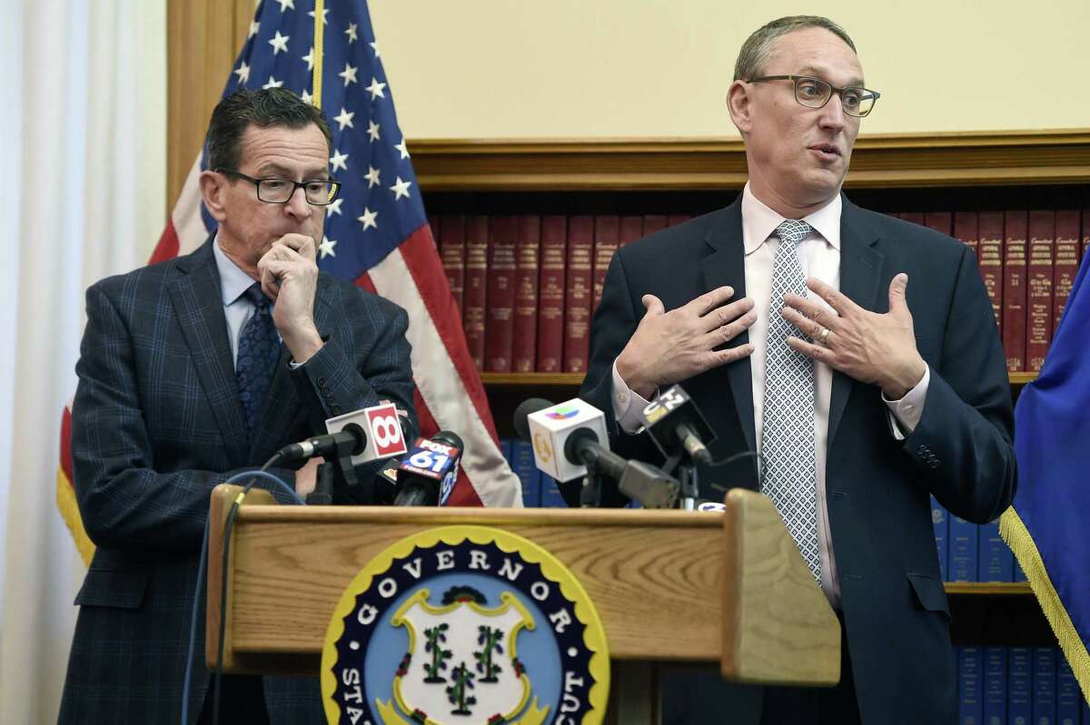 Gov. Dannel P. Malloy, left, listens as Ben Barnes, Secretary of the State of Connecticut Office of Policy and Management, right, speaks about the budget adjustments that they are proposing for the 2019 Fiscal Year during a press conference at the state Capitol.