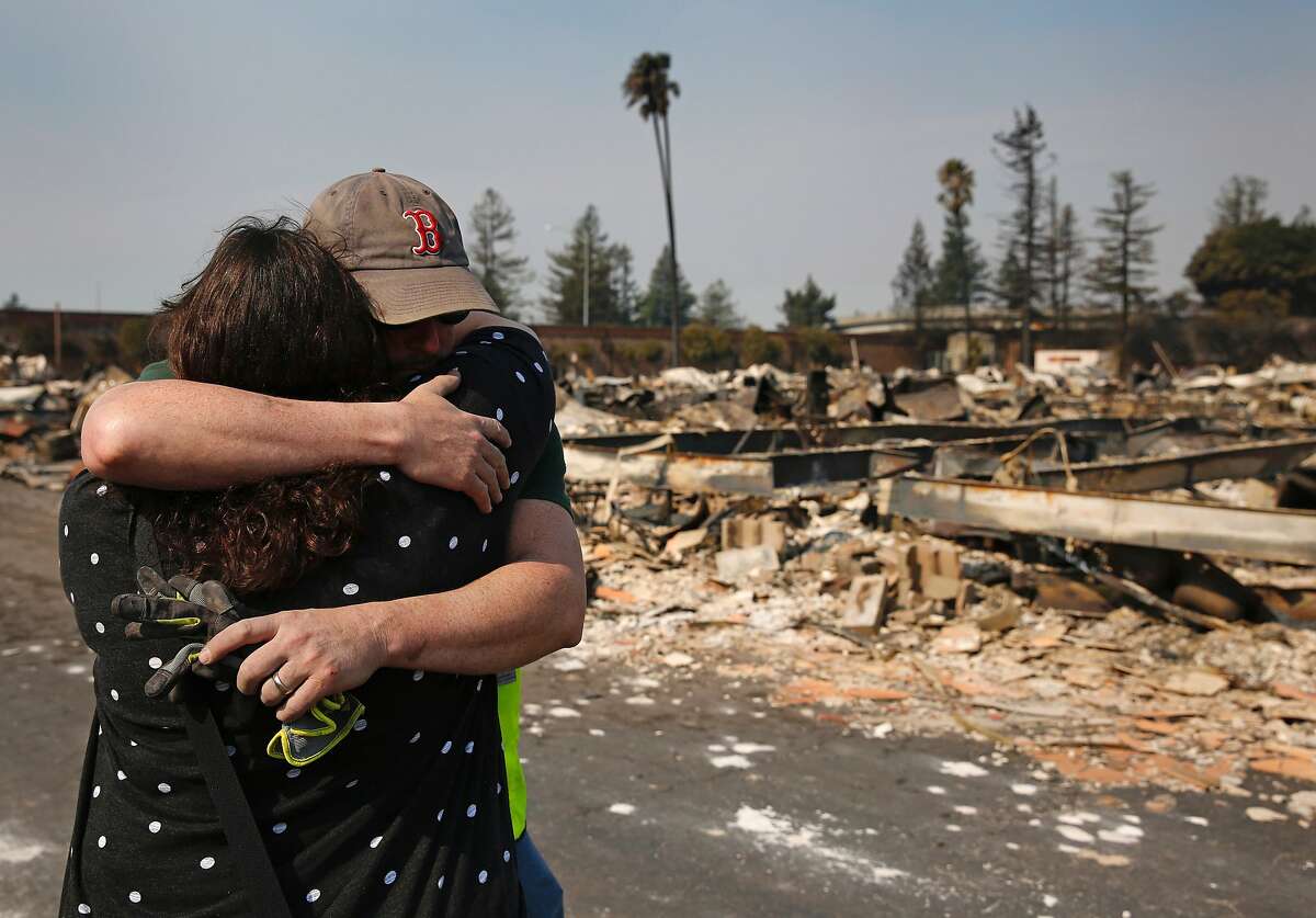 Family members embrace at a destroyed home containing the remains, they believe, of their family member at Journey's End mobile home park Oct. 11, 2017 in Santa Rosa, Calif. Most of the mobile homes were destroyed in the blaze, except for the last row of homes, reportedly because a resident named Priest stayed behind and fought the blaze with a hose the fire department gave him.