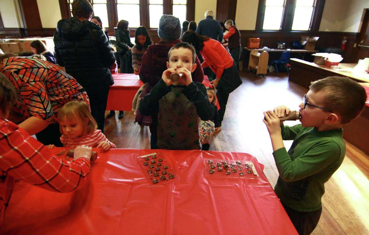 Vincent Murphy, 8, of Monroe, in center, and his brother Alexander, 6, eat chocolate between making their candies during Pequot Library's Kids' Candymaking Workshop in Southport, Conn., on Tuesday Feb. 13, 2018. Kids from kindergarten to 8th grade were able to make chocolate treats for Valentine's Day. They were also able to use crafts to create their own gift box and card. For future events or information, visit: www.pequotlibrary.org