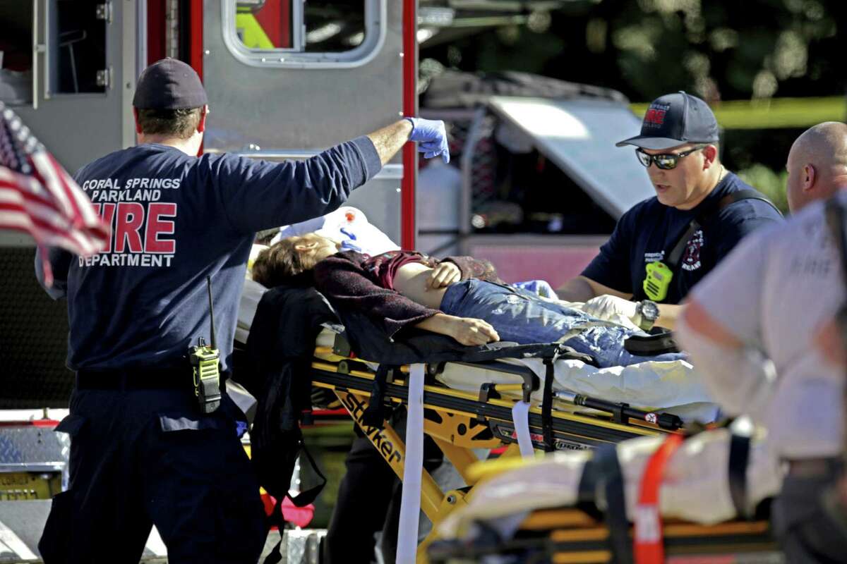 Medical personnel tend to a victim following a shooting at Marjory Stoneman Douglas High School in Parkland, Fla., on Wednesday, Feb. 14, 2018. (John McCall/South Florida Sun-Sentinel via AP)