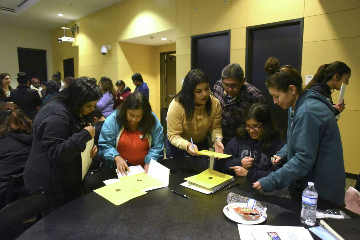 Parents and students work together to solve puzzles during a game as part of a new program called Family First at Texas A&M University-San Antonio on Tuesday, Feb. 13, 2018. The program offers afterschool classes to the parents of first generation college students.