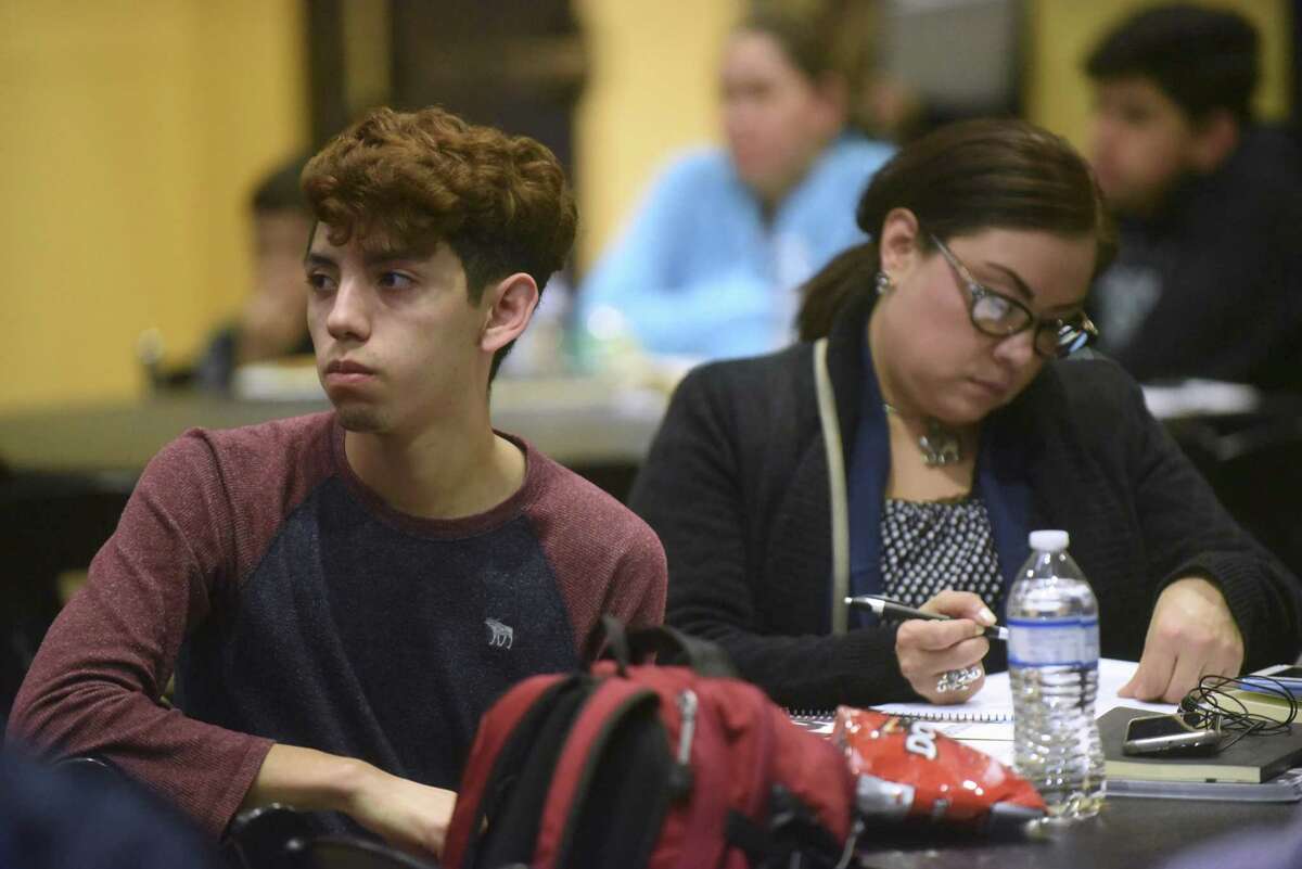 Student Presciliano Hernandez, listens as his mother, Jennifer Yanez, takes notes during a new program called Family First at Texas A&M University-San Antonio on Tuesday, Feb. 13, 2018. The program offers afterschool classes to the parents of first generation college students.