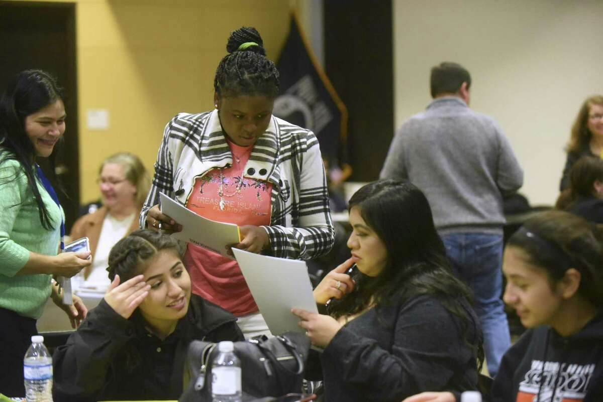 Student Melissa Gazamoundjou, standing, compares notes with others during a new program called Family First at Texas A&M University-San Antonio on Feb. 13. The program offers afterschool classes to the parents of first generation college students.