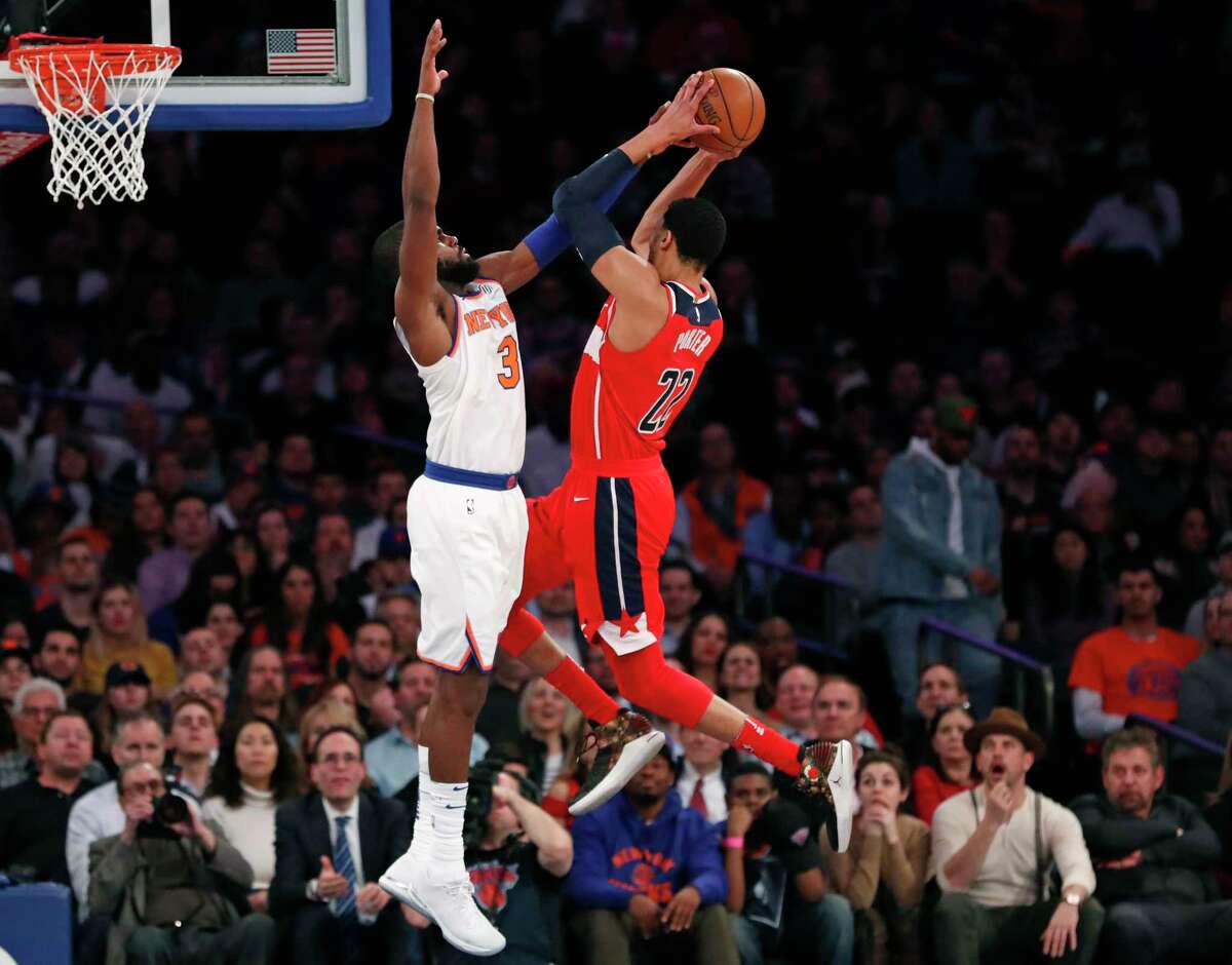 New York Knicks forward Tim Hardaway Jr. (3) fouls Washington Wizards forward Otto Porter Jr. (22) in the second half of an NBA basketball game in New York, Wednesday, Feb. 14, 2018. The Wizards defeated the Knicks 118-113. (AP Photo/Kathy Willens)