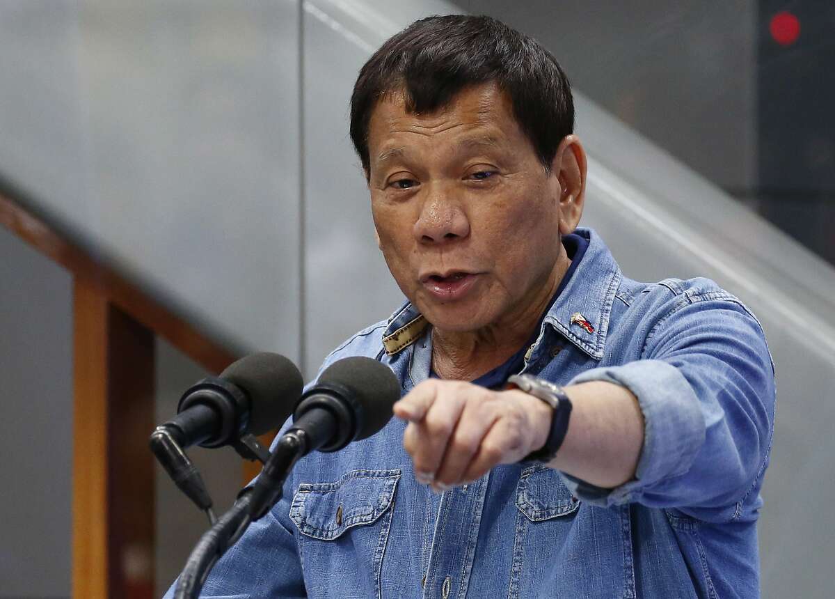 Philippine President Rodrigo Duterte jokes while addressing Filipino Overseas Workers who were repatriated from Kuwait Tuesday, Feb. 13, 2018 at the Ninoy Aquino International Airport in suburban Pasay city southeast of Manila, Philippines. Human rights groups condemned the Philippine president Tuesday for his remarks about troops shooting female communist rebels in the genitals to render them "useless," which they said can encourage sexual violence and war crimes. The left-wing group Karapatan said President Rodrigo Duterte "has distinguished himself as a frothing-in-the-mouth fascist who incites the worst violations of international humanitarian law." (AP Photo/Bullit Marquez)
