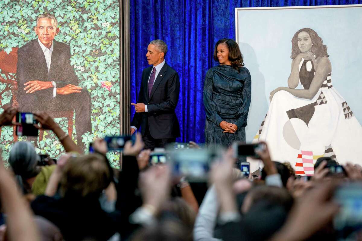 Former President Barack Obama and former First Lady Michelle Obama stand on stage together as their official portraits are unveiled at a ceremony at the Smithsonian's National Portrait Gallery, Monday, Feb. 12, 2018, in Washington, D.C.