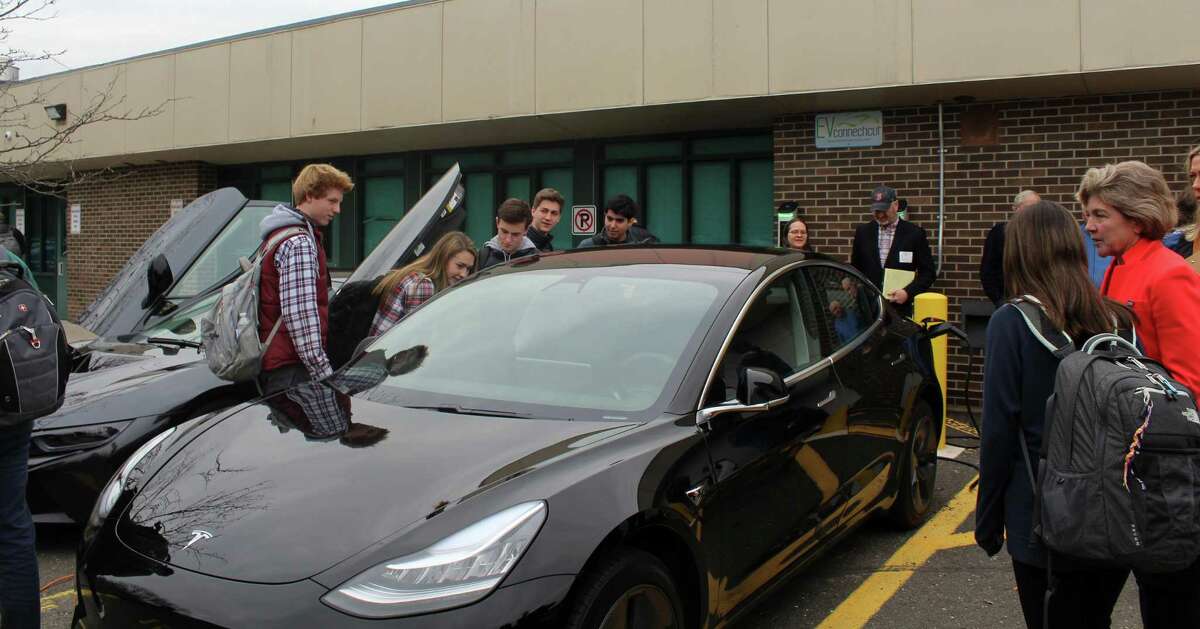 Students at Staples High School look at Westport resident Bruck Becker’s Tesla Model 3 at an event showcasing his new vehicle on Wednesday.