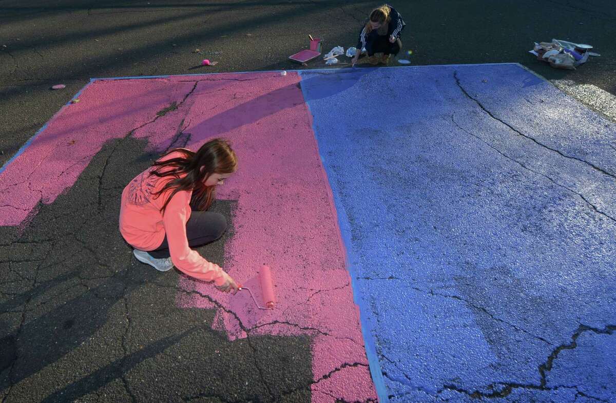Seniors at Brien McMahon High School including Chrissy Kirst paint their parking spaces Friday, Nov. 17, 2017, at the school. To celebrate all students and to build a culture of inclusiveness, Brien McMahon High School creates an annual lip dub video.