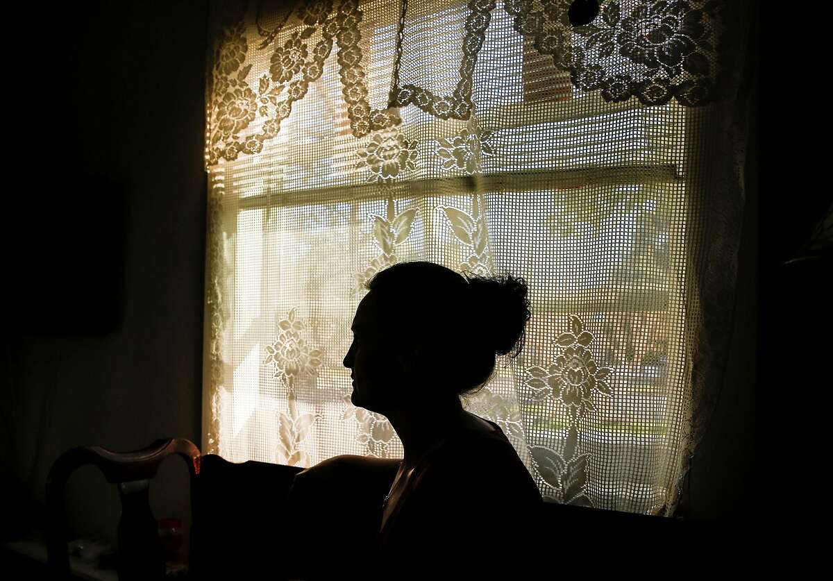 The mother of a 14-year-old girl who formerly resided at Mary Graham Children's Shelter is seen silhouetted in the window of her home Thursday, Feb. 15, 2018 in Stockton, Calif.