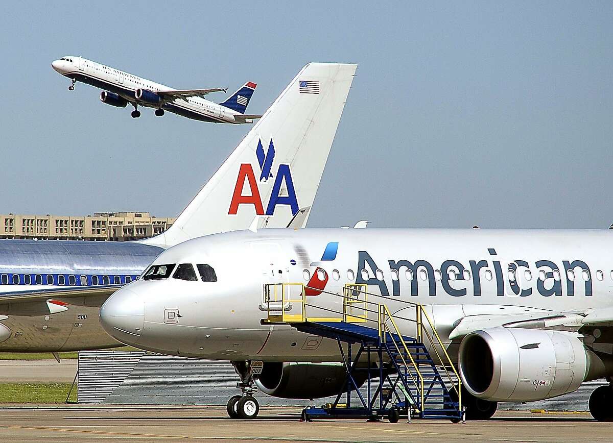 A U.S. Airways jet takes off over an old and new paint designs on American Airlines planes at the DFW International Airport, TX, Monday, May 5, 2014. (Star-Telegram/Max Faulkner)