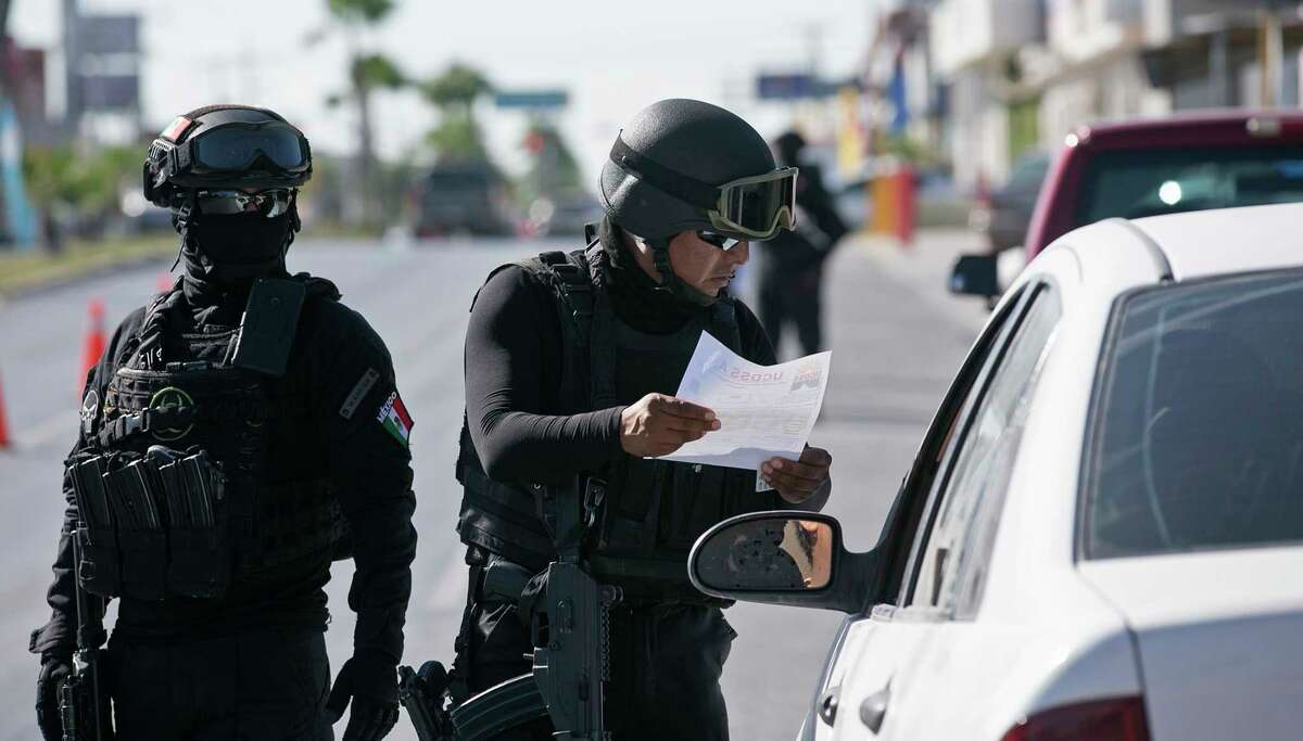 Tamaulipas State Police officers review paperwork on a vehicle at a checkpoint in Reynosa, Mexico, Sunday, Nov. 5, 2017. Tamaulipas Gov. Francisco Cabeza de Vaca initiated the checkpoints in October as an effort to curb criminal groupÃ©?•s violence including carjackings. The police searches for stolen vehicles, drugs and guns.