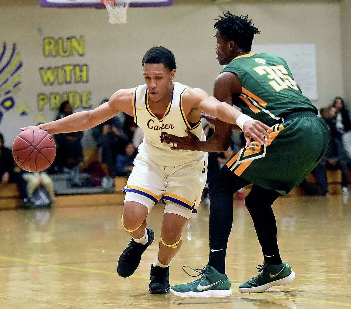 Career sophomore guard Savee'on Avery drives past Trinity Catholic senior forward Dimitry Moise in the first half of a non-conference game, Friday, Feb. 16, 2018, at the Hill Regional Career High School in New Haven. Trinity Catholic-Stamford won, 64-61.