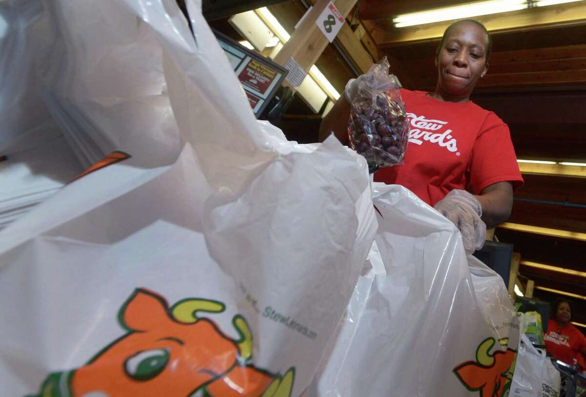 Cashier Milmene Joseph bags groceries in Stew Leonard’s iconic plastic bags into her cart at the store Wednesday in Norwalk. Some Common Council members are considering whether plastic bags should be banned in the city.