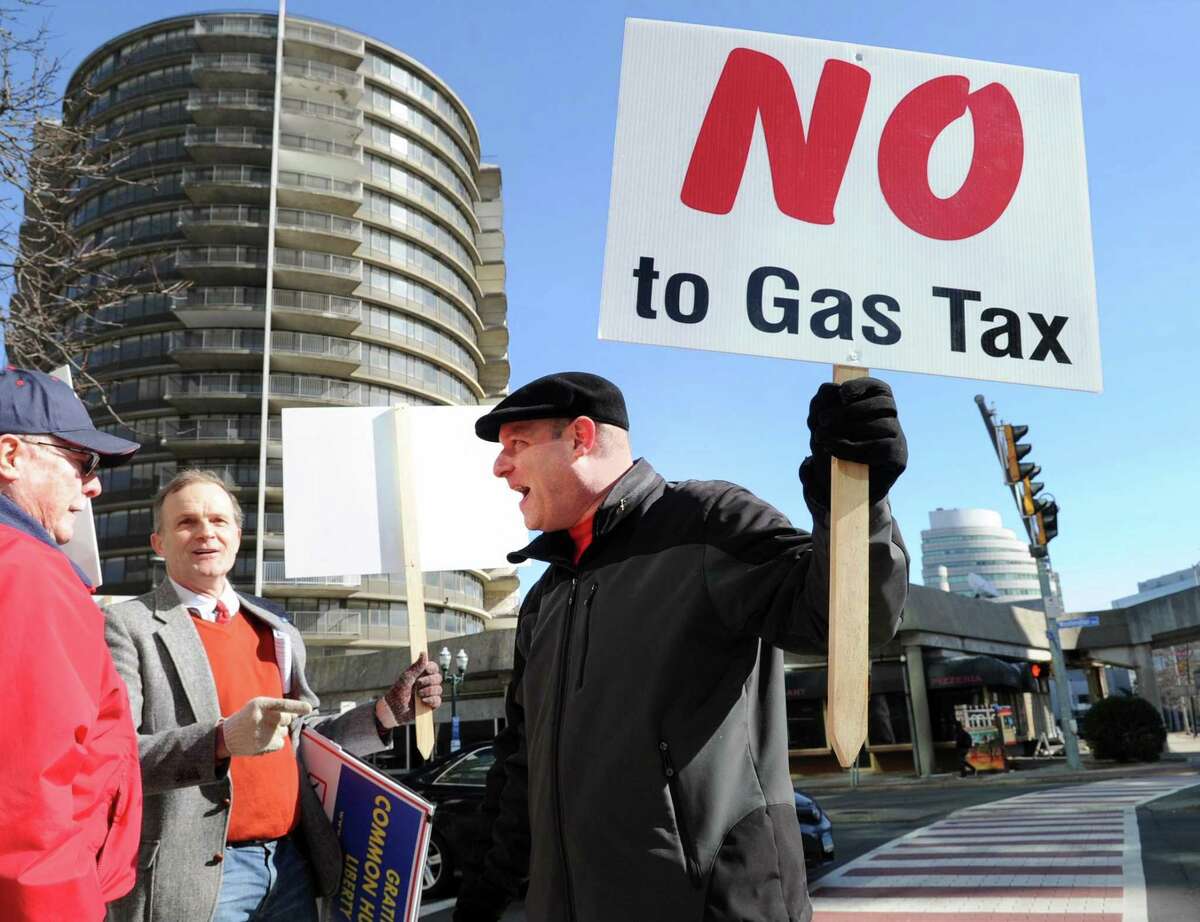 "No to Gas Tax," reads the sign held by a Stamford trucking company owner Patrick Sasser during the protest against tolls, a new gas tax and tire tax, held in front of the Stamford Goverment Center, Stamford, Conn., Saturday, Feb. 17, 2018. Sasser said about the proposed taxes "these taxes would really hurt small businesses. We are already taxed to death." Roughly 75 people attended the protest that was accompanied by a caravan of trucks circling the center honking their horns in support of the protestors. Gov. Dannel P. Malloy wants legislators to pass measures including electronic tolls, an increase in state gasoline taxes and a new tax on the sale of tires, to pay for Connecticut's transportation system that he says is facing a serious fuding crisis.