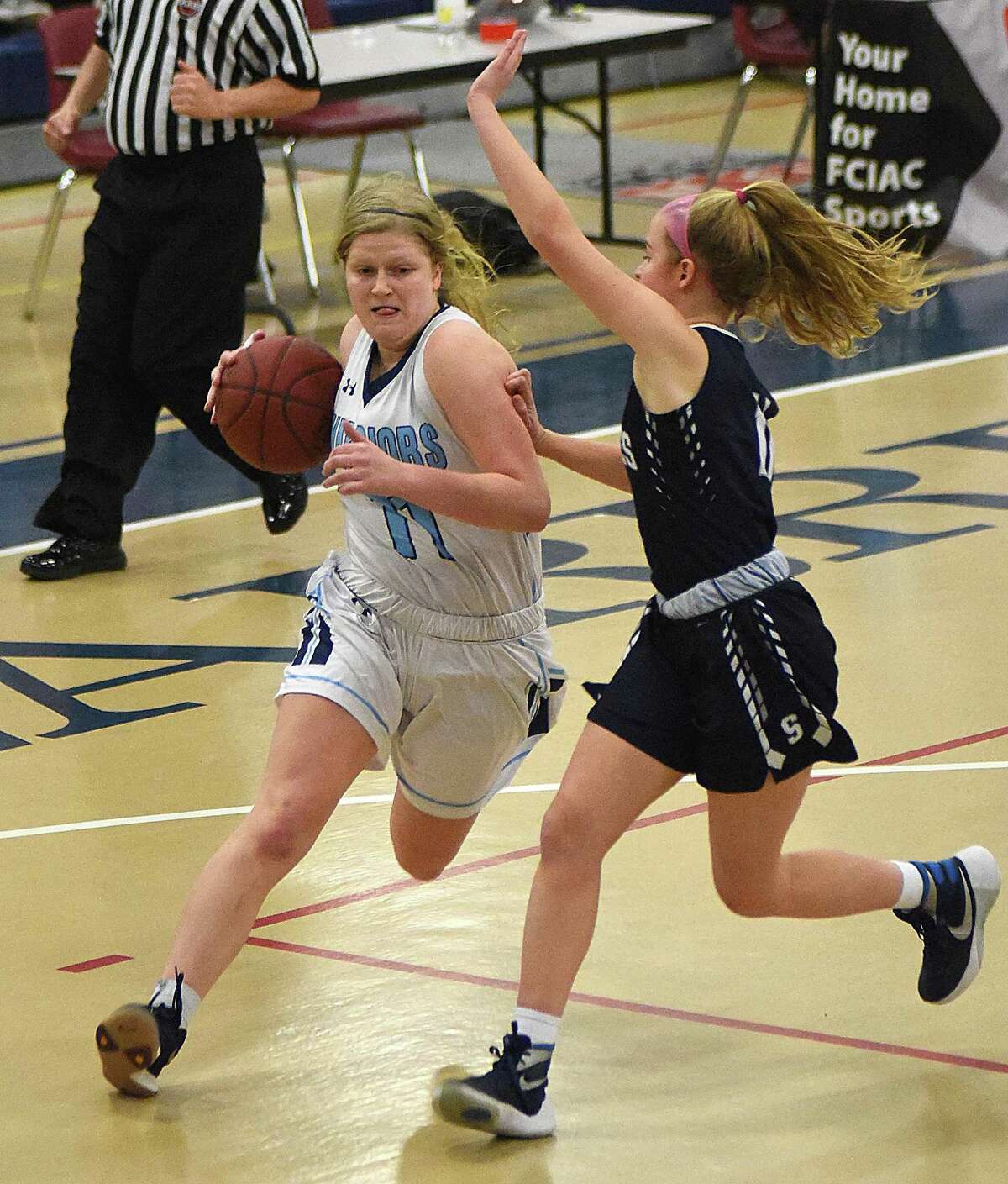 Claire Gulbin of Wilton, left, drives past Staples' Elle Fair during Saturday's FCIAC girls basketball quarterfinal at the Zeoli Field House in Wilton.
