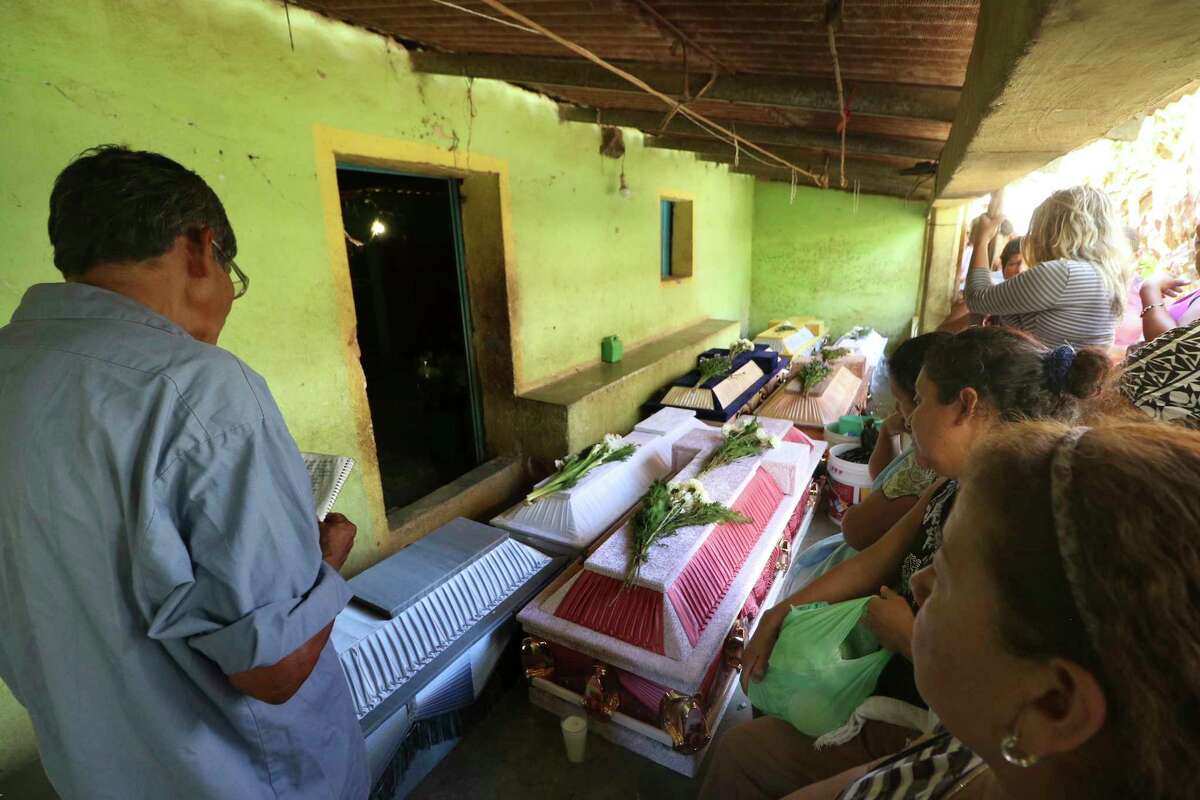 Family members mourn their dead after a helicopter carrying officials assessing damage from Friday's earthquake crashed and killed 13 people and injured 15, all of them on the ground.