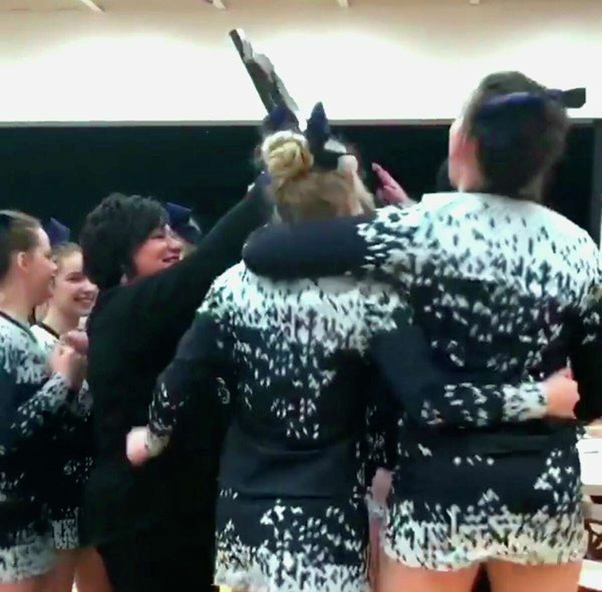 Meridian cheer coach Val McKenzie, left, and the Mustangs' team celebrate their Division 4 district title on Saturday at Holton High School. (Photo courtesy of Val McKenzie)