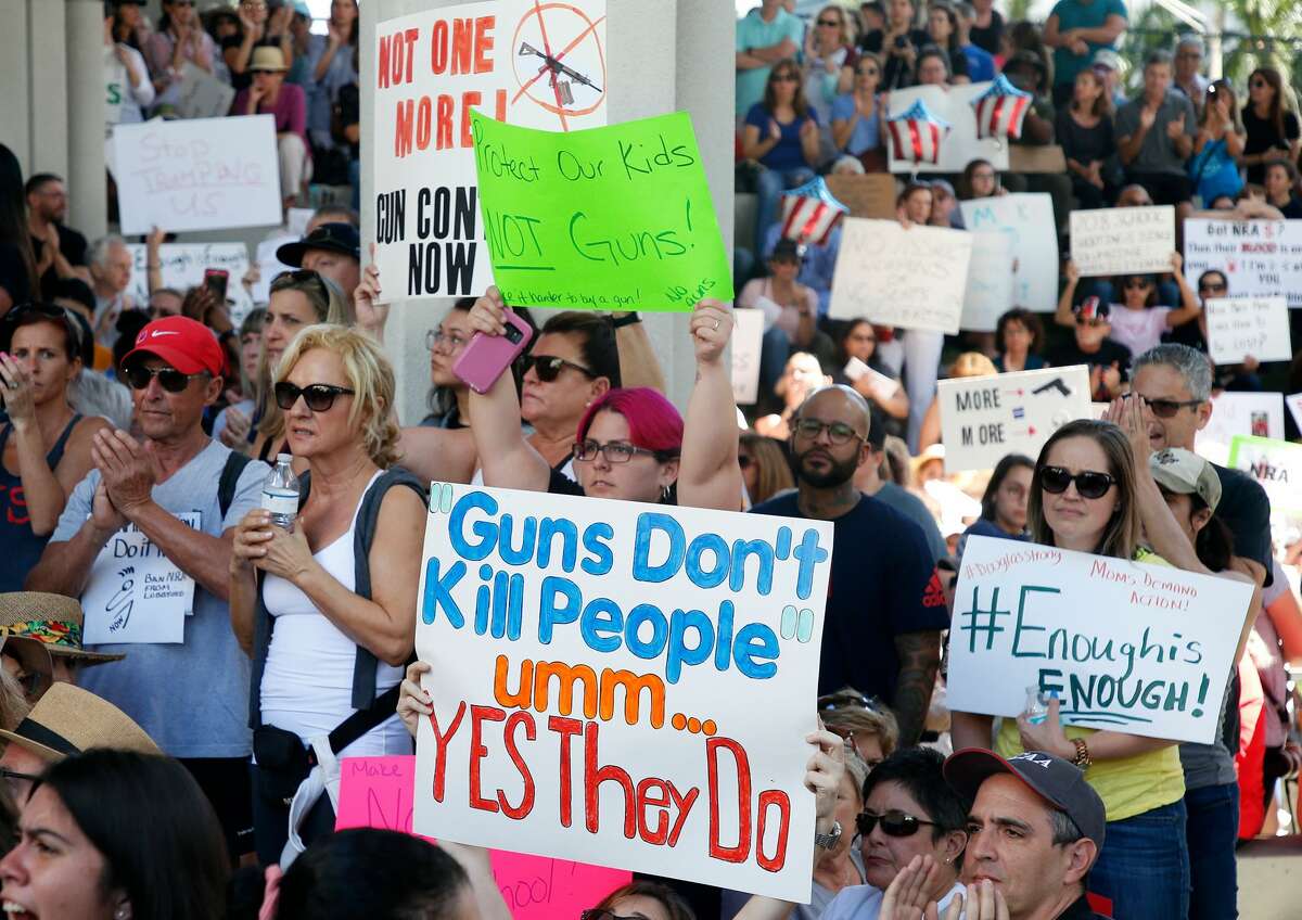 Protesters hold signs at a rally for gun control at the Broward County Federal Courthouse in Fort Lauderdale, Florida on February 17, 2018. Seventeen perished and more than a dozen were wounded in the hail of bullets at Marjory Stoneman Douglas High School in Parkland,Florida the latest mass shooting to devastate a small US community and renew calls for gun control.