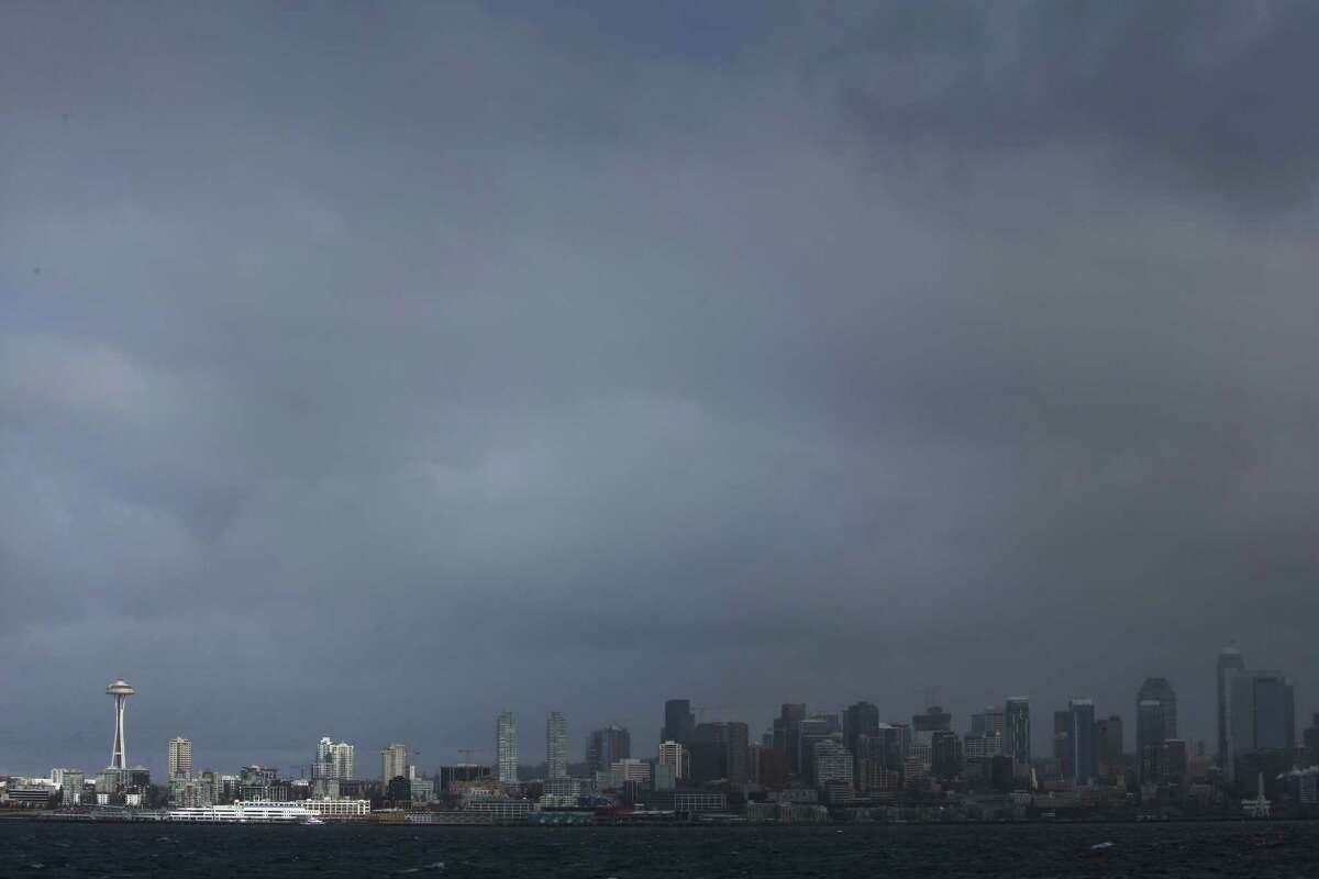 A spot of sun lights up the Space Needle as storm clouds hang over downtown Seattle, Sunday, Feb. 18, 2018. High winds and small amounts of snow blew through the city throughout the day.