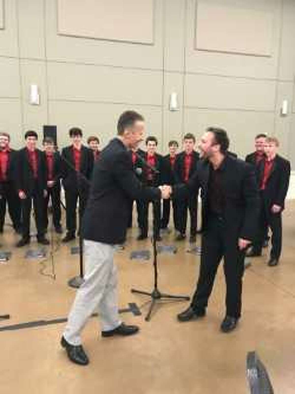 Program Chair Mike Sproba, left, thanks Cameron Carnley, Director of the Montgomery High School Menâs Chorale for their performance during the Conroe Noon Lions Club annual Sweetheartâs Day.