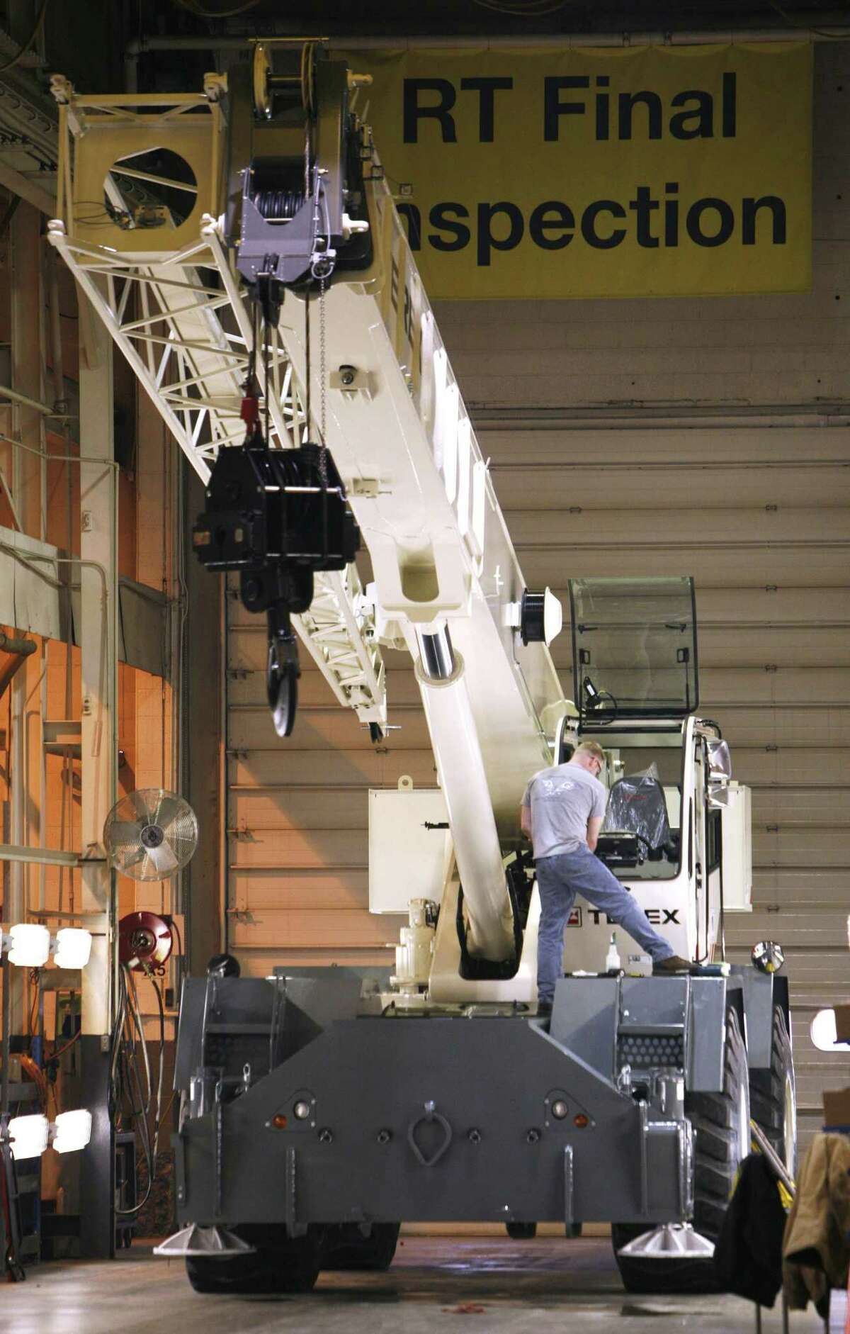 A worker inspects a crane in April 2008 at a Terex plant in Waverly, Iowa, which the company closed in 2016 amid a consolidation of U.S. plants. In 2017 for the first time in two years, Westport, Conn.-based Terex added to its U.S. workforce, with 5,000 workers as of December from 4,900 the year before. (AP Photo/Charlie Neibergall)