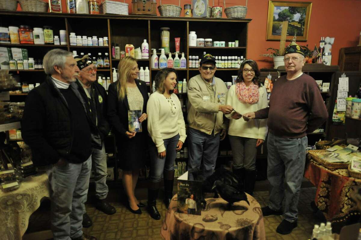 Torrington veteran Mike Galitello donated proceeds from his third book to aid city veterans Friday, with plans to write more in the future. From left: Rob Carr, American Legion Post 38 Commander Bruce Falls, State Rep. Michelle Cook, D-Torrington, Isabella Pinto, Galitello, Olivia Pinto, Torrington Veterans Service Office manager Bud Atwood, and Pam Pinto.