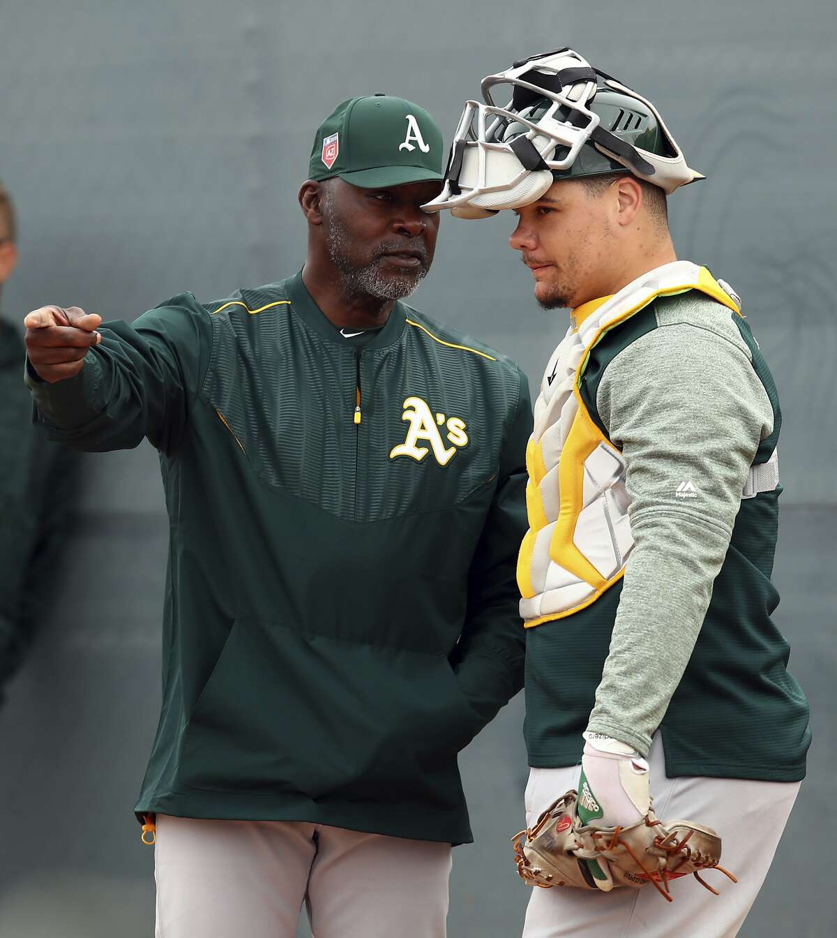 Oakland Athletics special instructor Dave Stewart, left, speaks with catcher Bruce Maxwell during a spring training baseball practice on Friday, Feb. 16, 2018 in Mesa, Ariz. (AP Photo/Ben Margot)