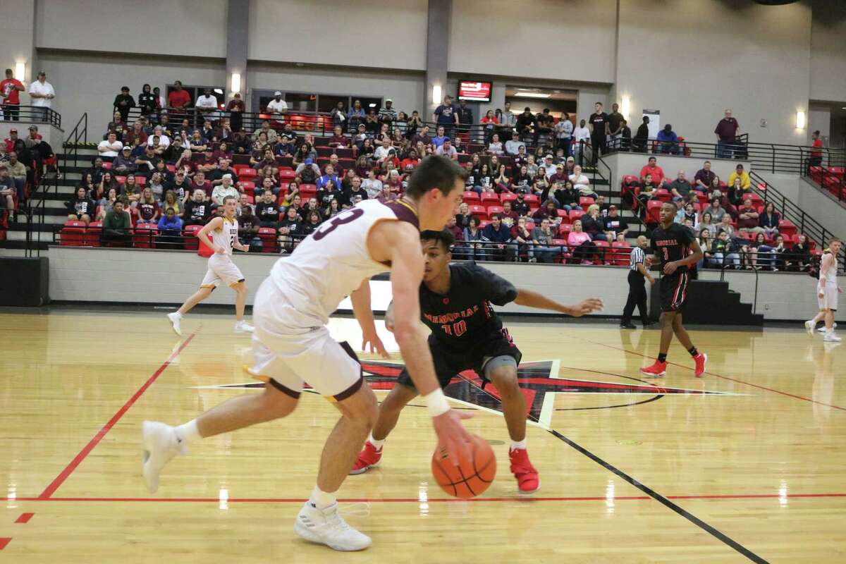 Zach Walker confronts Dylan Cook (10) and the Goose Creek Memorial pressure at mid-court during Monday night's bi-district game. Walker finished with 18 points.
