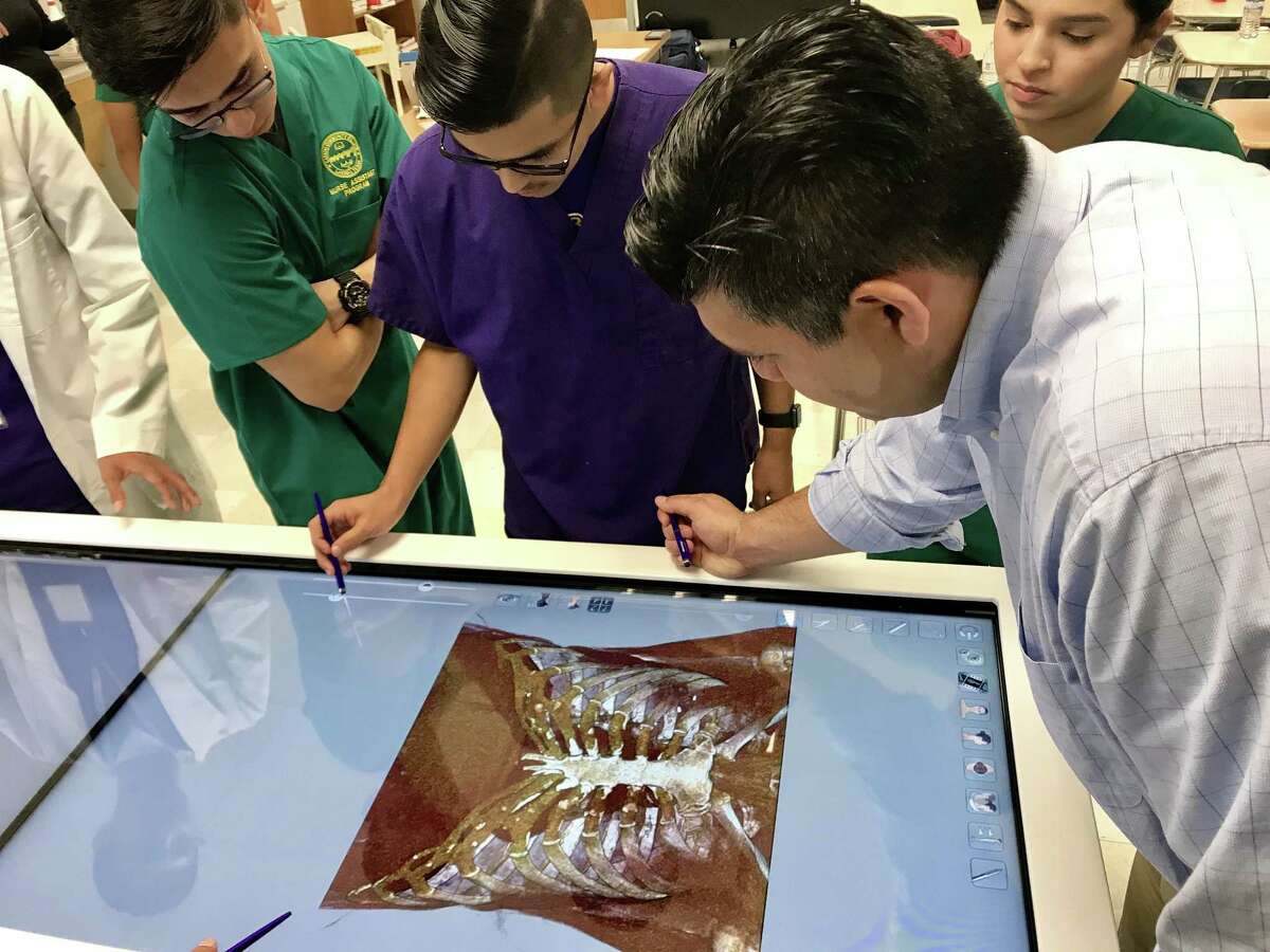 Charles Dalrymple, an anatomy teacher at LBJ High School, studies the thoracic cavity of the human body using the Anatomage Table with his students.
