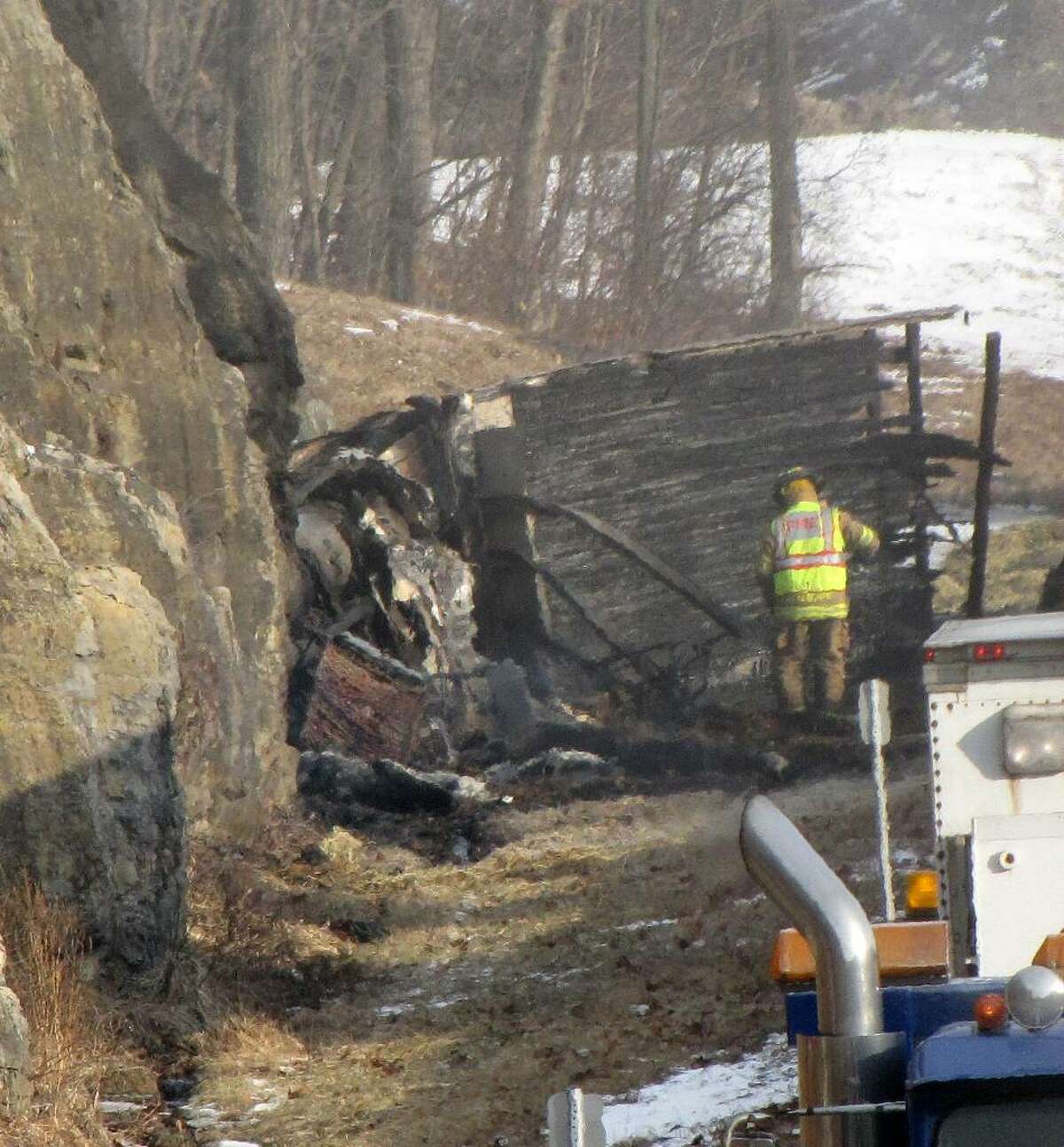 A firefighter sifts through the wreckage at the scene of a tractor-trailer accident on the New York State Thruway between exits 20 and 21 in which the driver died.